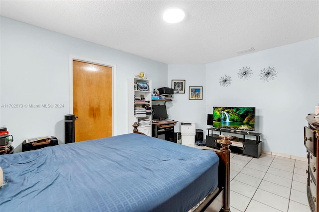 tiled bedroom featuring a textured ceiling