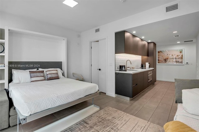 bedroom featuring light tile patterned floors and sink