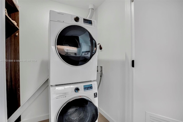 clothes washing area featuring stacked washer and clothes dryer