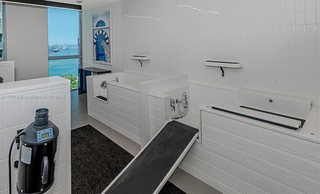 bathroom with a washtub and tile patterned flooring