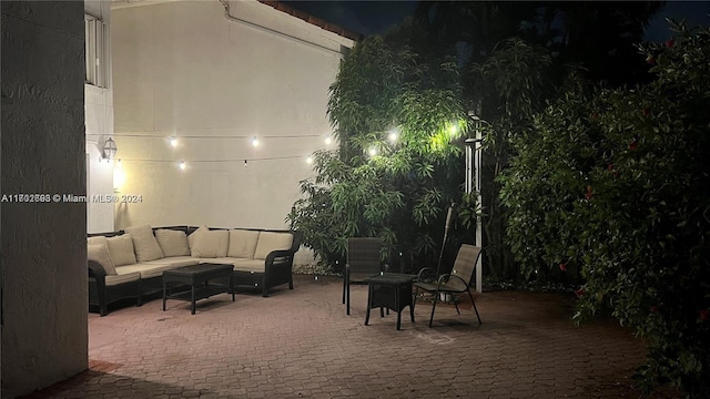 patio at night featuring an outdoor living space