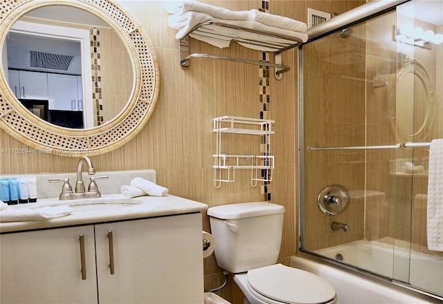 full bathroom featuring vanity, toilet, and enclosed tub / shower combo