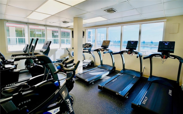 gym with a paneled ceiling and a wealth of natural light