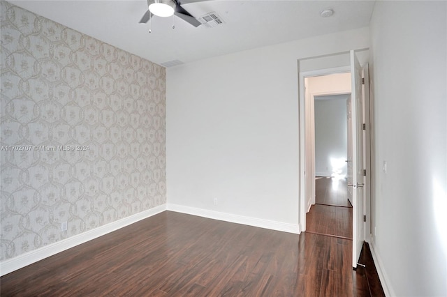 empty room featuring ceiling fan and dark hardwood / wood-style flooring