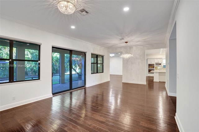 unfurnished living room featuring crown molding, dark hardwood / wood-style flooring, and an inviting chandelier