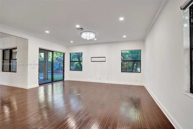 unfurnished room featuring a chandelier, dark hardwood / wood-style floors, and crown molding