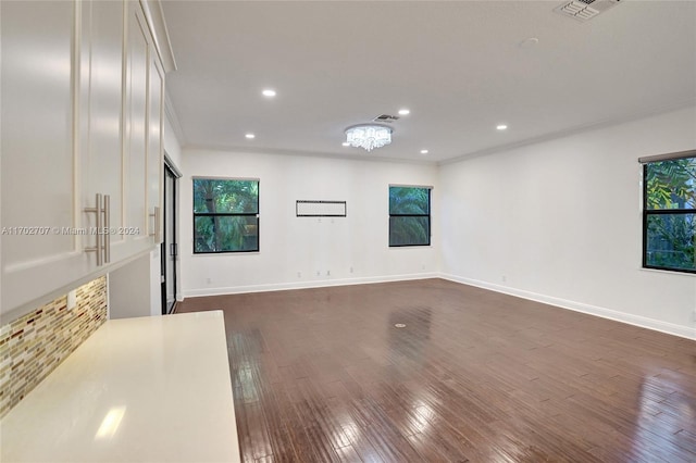 interior space with dark hardwood / wood-style flooring, a chandelier, and ornamental molding