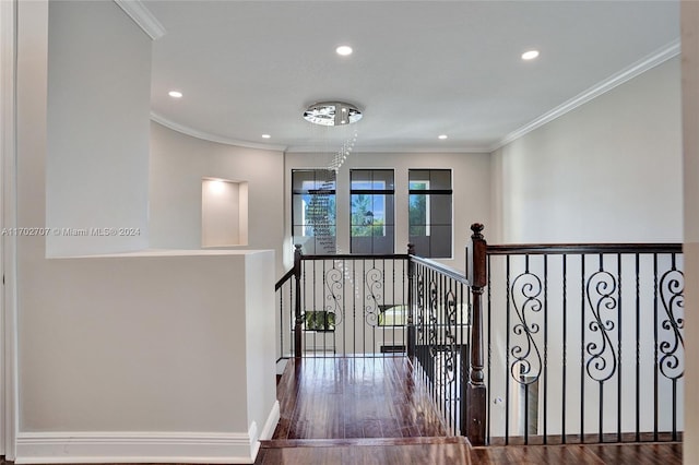 stairway featuring a chandelier, wood-type flooring, and ornamental molding