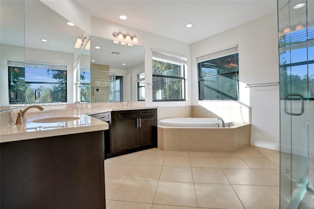 bathroom featuring plus walk in shower, vanity, and tile patterned floors