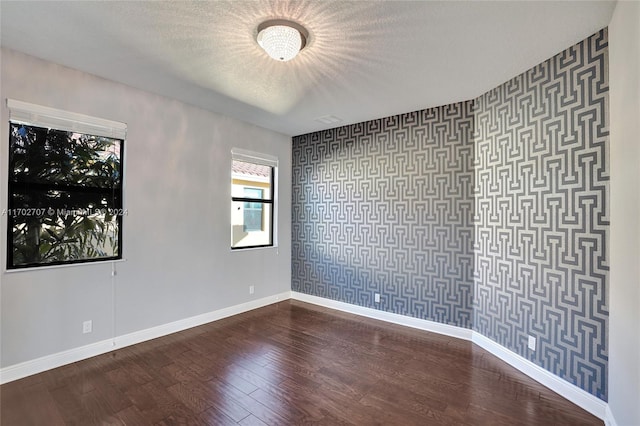 spare room featuring wood-type flooring and a textured ceiling