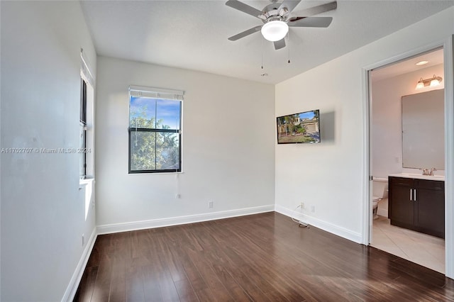 spare room featuring hardwood / wood-style flooring, ceiling fan, and sink