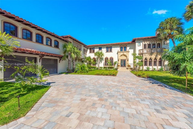 mediterranean / spanish house with a balcony, a front yard, and a garage