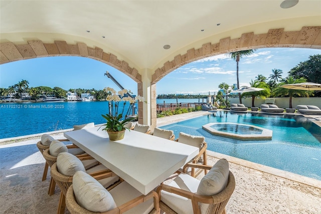 view of pool with a water view, an in ground hot tub, and a patio