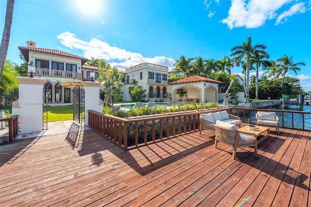 wooden deck featuring a water view and outdoor lounge area