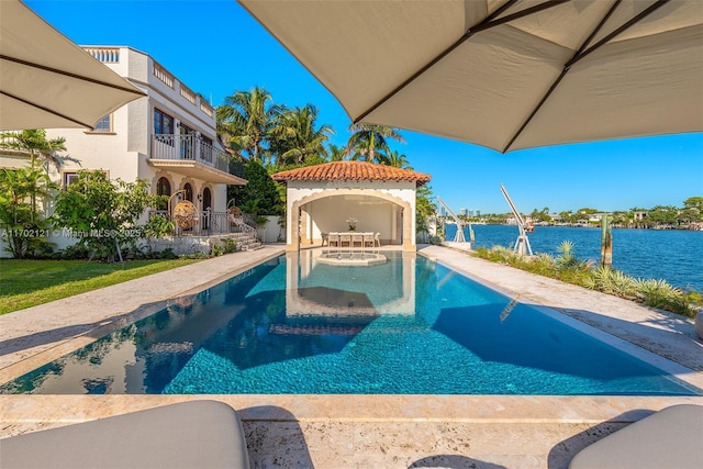 view of pool with a water view and a patio