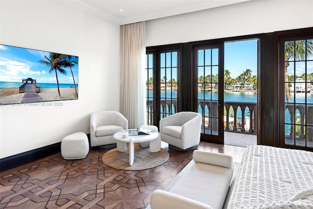 bedroom featuring crown molding, a water view, french doors, and access to outside