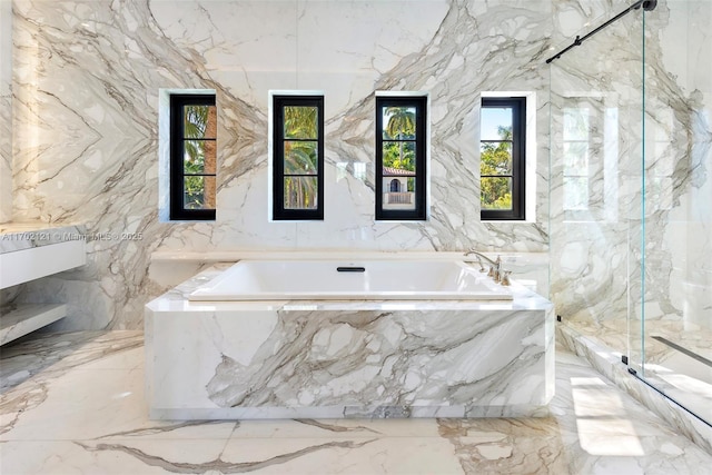 bathroom featuring tile walls and separate shower and tub