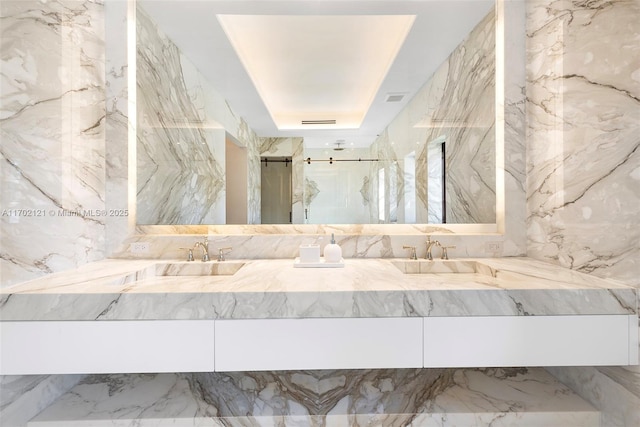 bathroom featuring an enclosed shower, vanity, and a tray ceiling