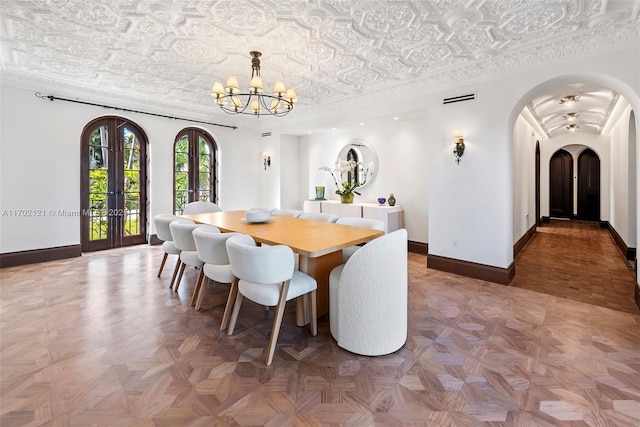 dining room with ornamental molding, parquet flooring, french doors, and a notable chandelier