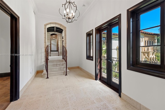 interior space featuring an inviting chandelier, ornamental molding, and french doors