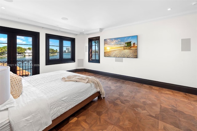 bedroom featuring access to exterior, multiple windows, a water view, and french doors