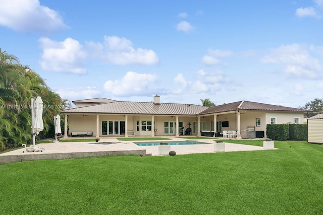 rear view of house with a patio, ceiling fan, and a lawn