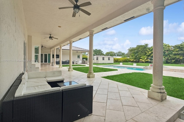 view of patio featuring an outbuilding, ceiling fan, and an outdoor living space