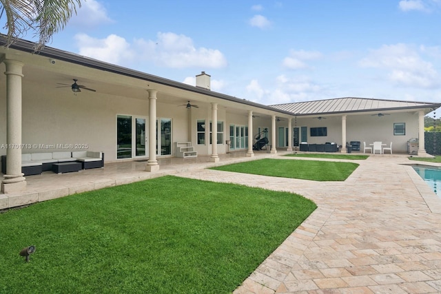 rear view of house with an outdoor living space, ceiling fan, and a lawn