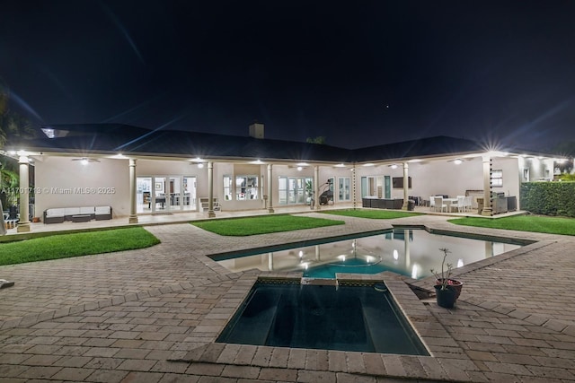 pool at twilight with an in ground hot tub, french doors, a patio, and outdoor lounge area