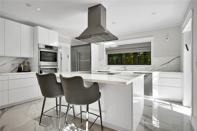 kitchen featuring a center island, light stone countertops, island range hood, white cabinetry, and stainless steel appliances