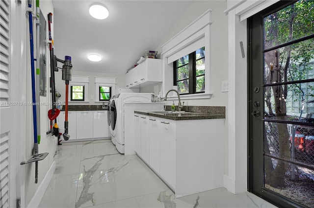 clothes washing area featuring washer / clothes dryer, sink, and cabinets