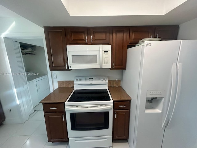 kitchen with washer and dryer, light tile patterned floors, white appliances, and dark brown cabinets