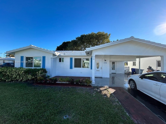 ranch-style house with a carport and a front yard