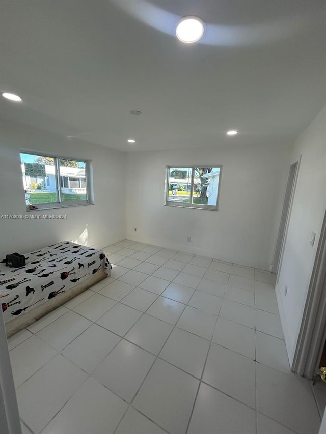 basement with a wealth of natural light and light tile patterned flooring