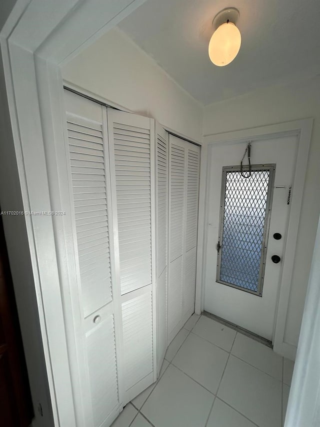 doorway to outside with light tile patterned floors