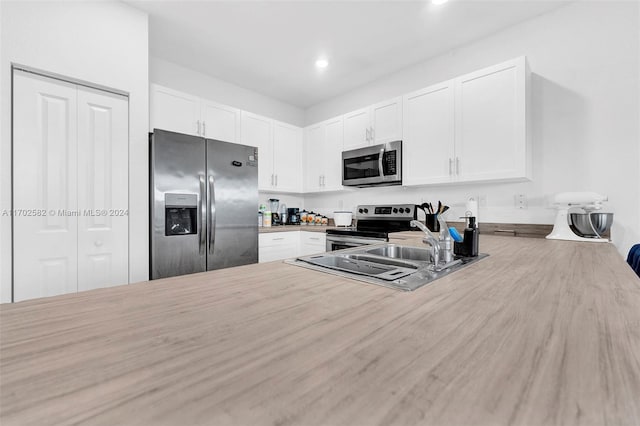 kitchen with sink, white cabinets, and stainless steel appliances