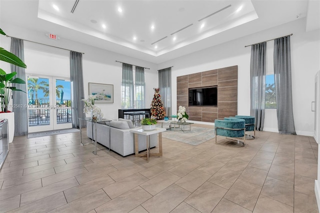 tiled living room with a raised ceiling and a wealth of natural light