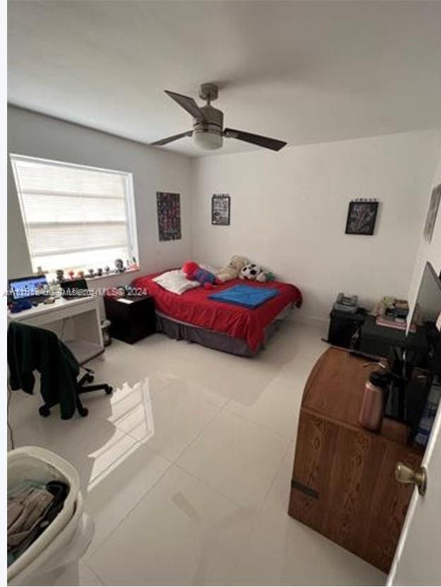 bedroom with ceiling fan and tile patterned flooring