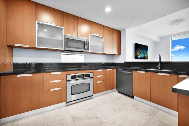 kitchen with black appliances, sink, and dark stone counters