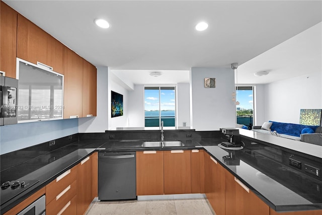 kitchen featuring kitchen peninsula, appliances with stainless steel finishes, dark stone countertops, and sink