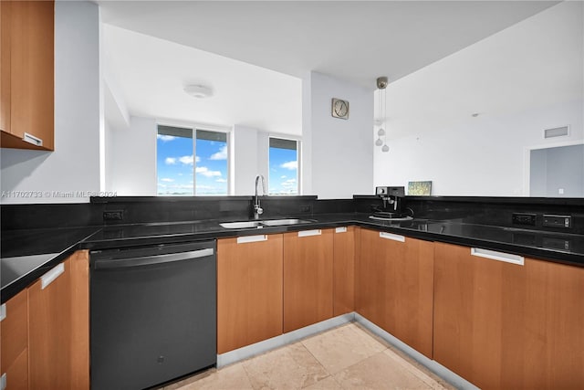 kitchen with pendant lighting, dishwasher, dark stone counters, and sink