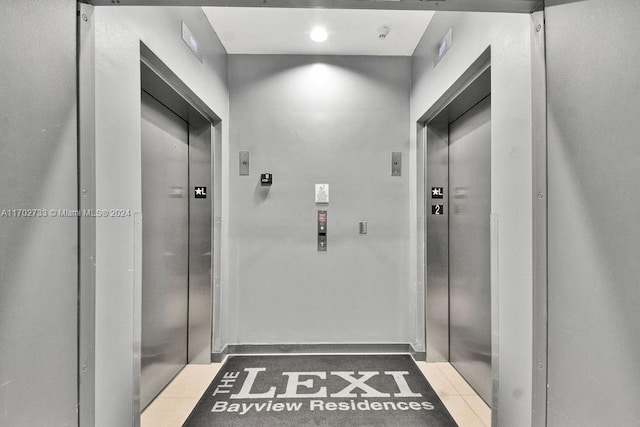 hall featuring elevator and tile patterned flooring