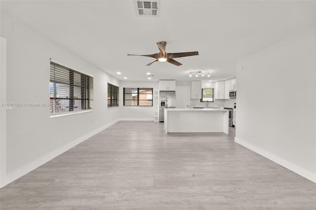 unfurnished living room with ceiling fan and light hardwood / wood-style flooring