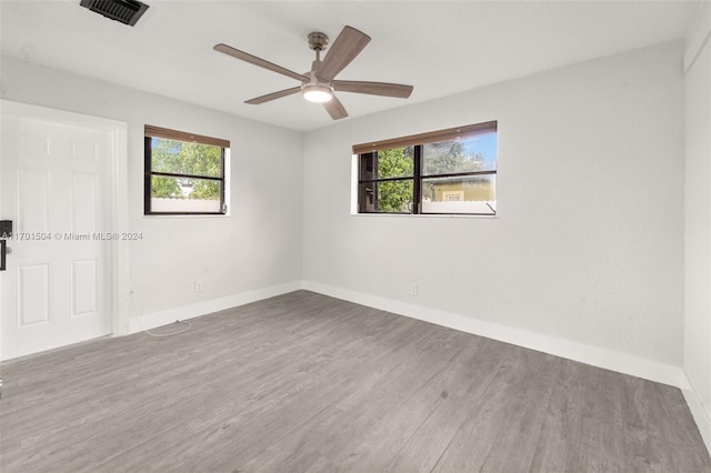 unfurnished room with hardwood / wood-style floors, plenty of natural light, and ceiling fan