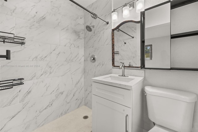 bathroom featuring vanity, toilet, and tiled shower