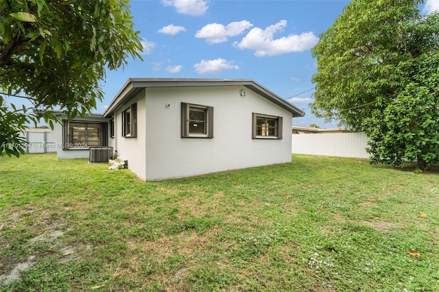 view of side of property featuring a yard and central air condition unit