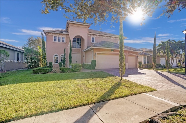 mediterranean / spanish-style home featuring a front yard and a garage