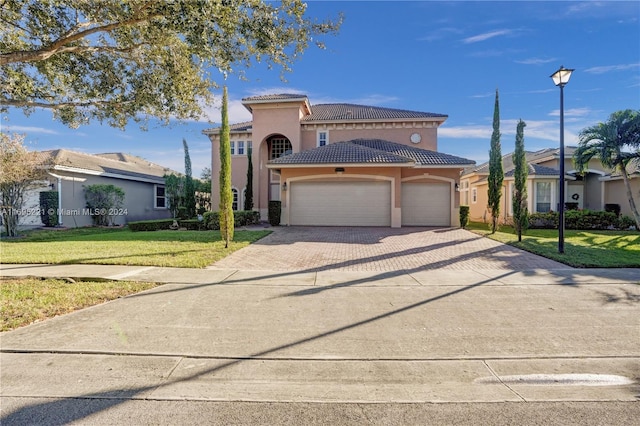 mediterranean / spanish-style home with a garage and a front lawn