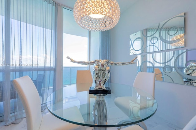 dining room featuring a water view, an inviting chandelier, and a healthy amount of sunlight