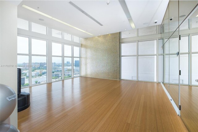 interior space featuring hardwood / wood-style floors, a towering ceiling, and floor to ceiling windows